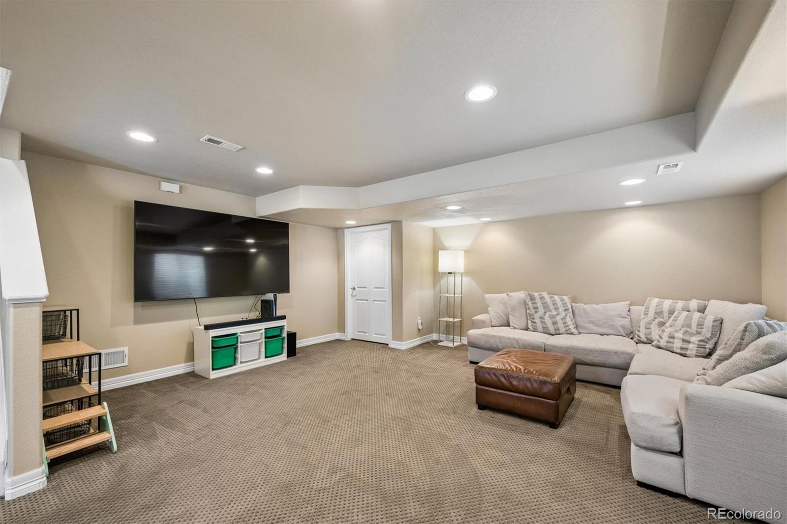 2677 Pemberly Avenue Highlands Ranch, CO 80126 - Photo 34 of 50 a living room with furniture and a flat screen tv