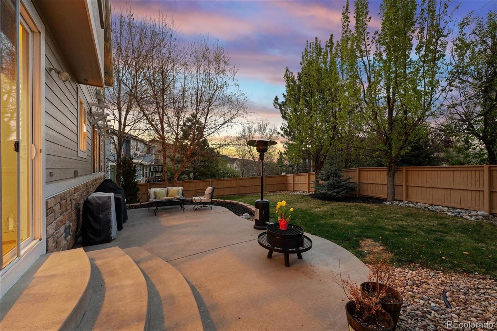 2677 Pemberly Avenue Highlands Ranch, CO 80126 - Photo 38 of 50 a view of a backyard with couches table and chairs and potted plants