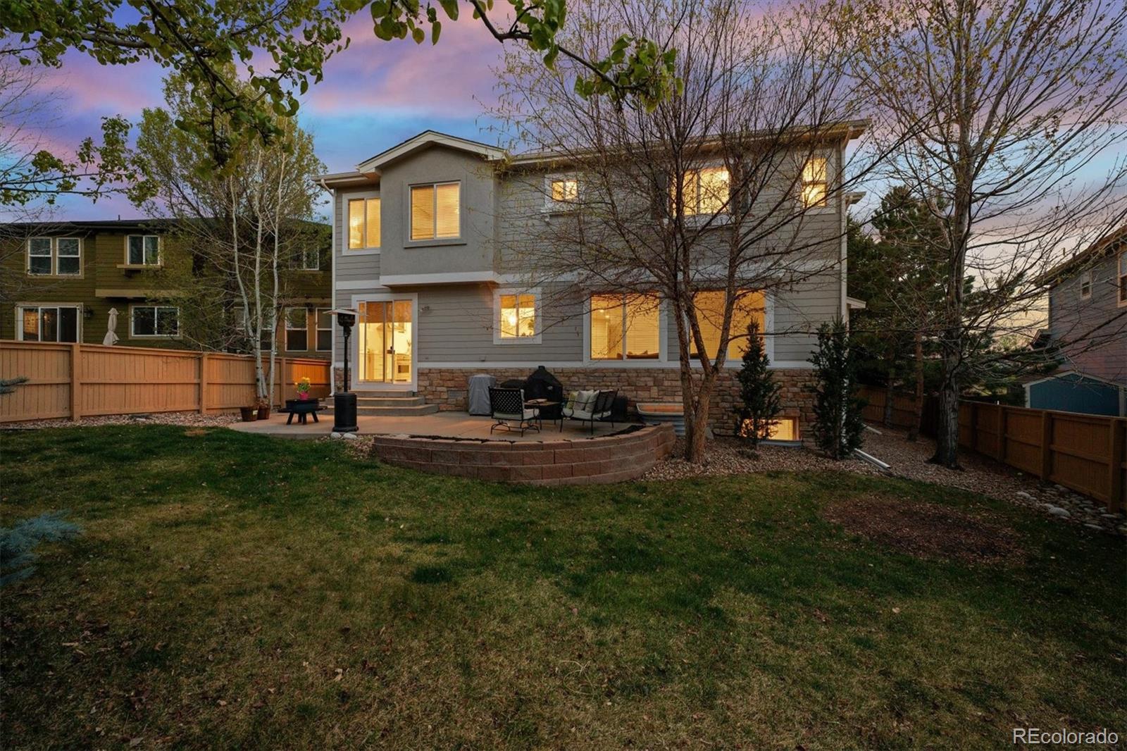 2677 Pemberly Avenue Highlands Ranch, CO 80126 - Photo 41 of 50 a view of a brick house with a big yard and large trees