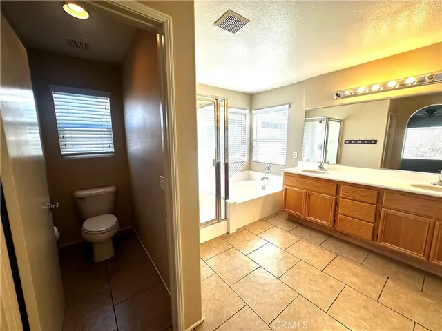 a spacious bathroom with a granite countertop sink mirror and bathtub