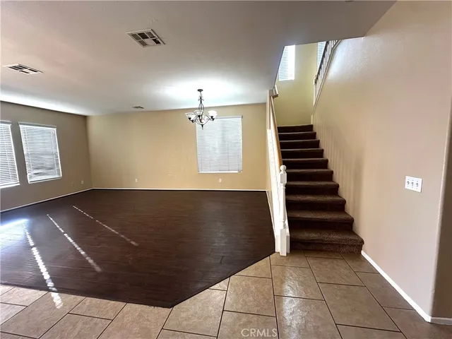 a view of a livingroom with a flesh screen tv and stairs