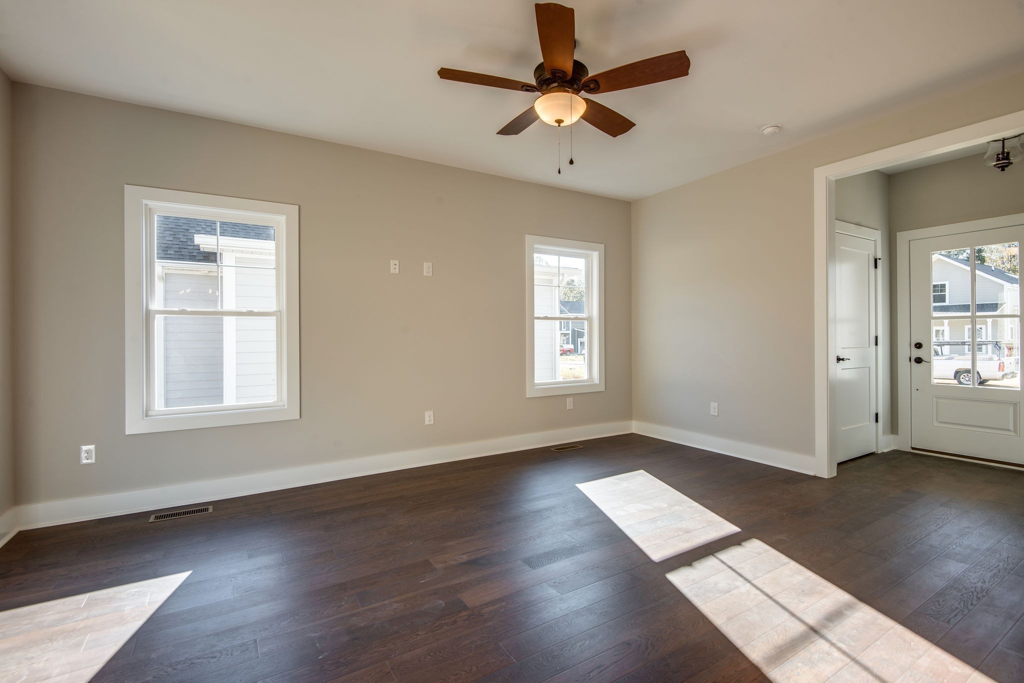 56 Sycamore Ridge Burns, TN 37029 - Photo 8 of 46 an empty room with wooden floor chandelier fan and windows