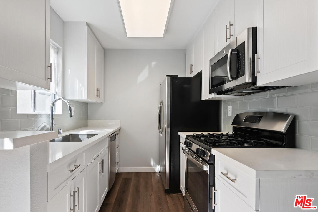 29239 Heathercliff Road, Unit 12 Malibu, CA 90265 - Photo 14 of 32 a kitchen with stainless steel appliances granite countertop a sink stove and refrigerator