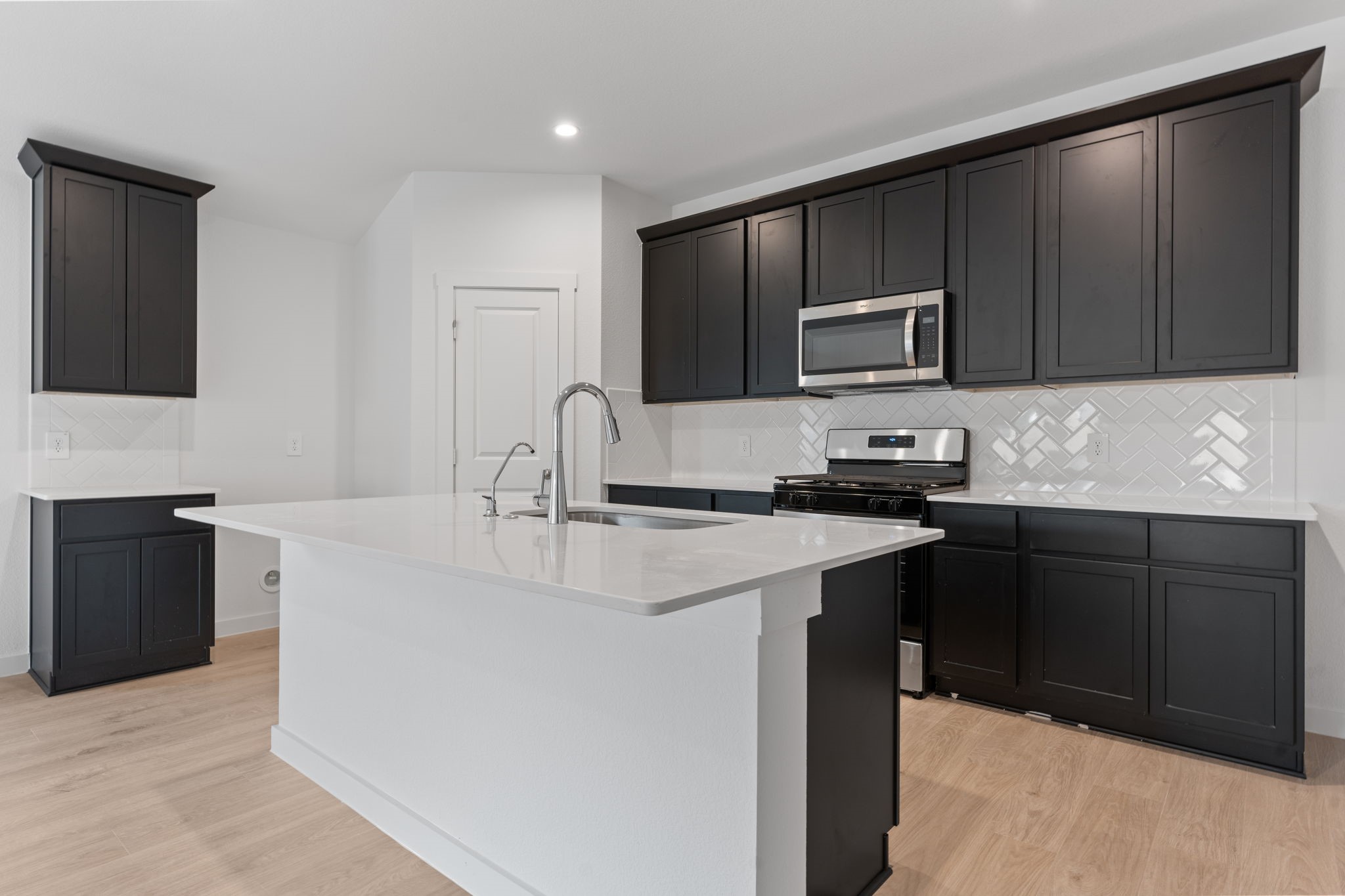 1603 Cinque Terre Way Richmond, TX 77406 - Photo 11 of 31 a kitchen with kitchen island granite countertop a sink and stove top oven