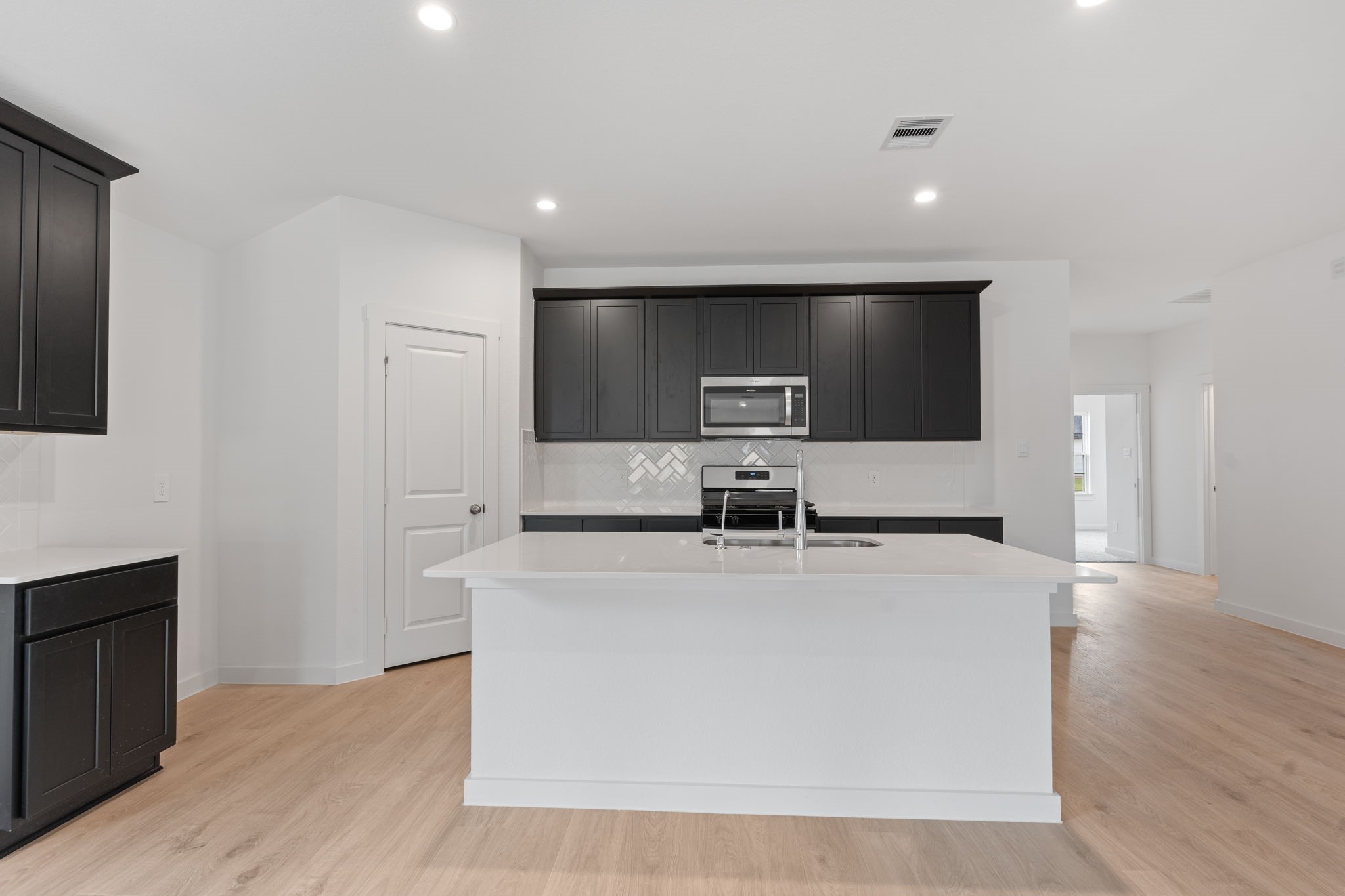 1603 Cinque Terre Way Richmond, TX 77406 - Photo 12 of 31 a view of kitchen island a sink a stove and wooden floor