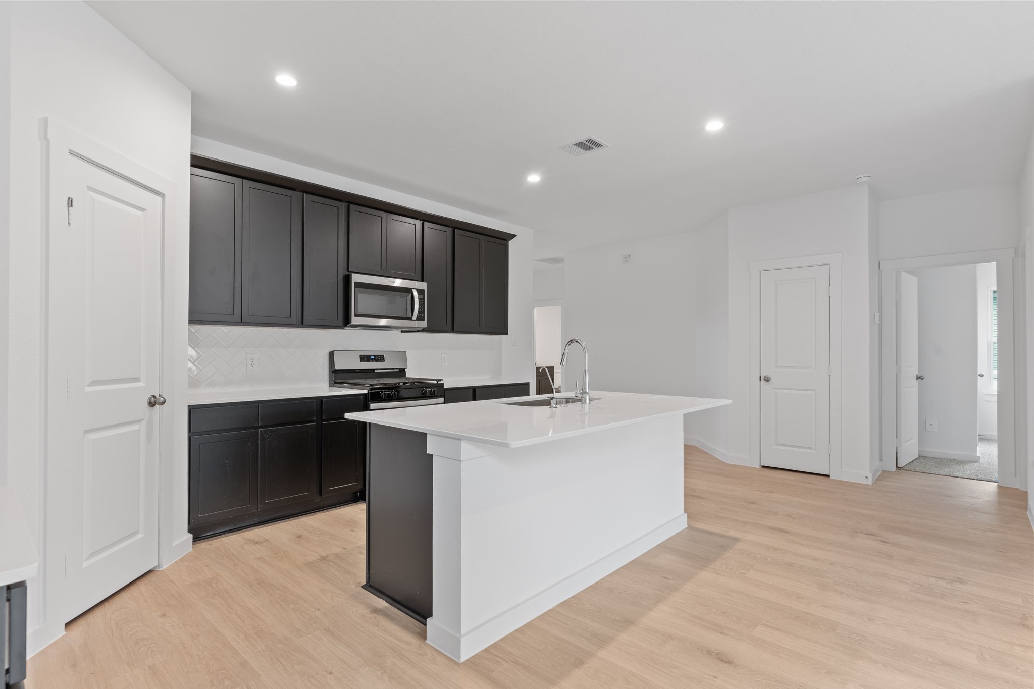 1603 Cinque Terre Way Richmond, TX 77406 - Photo 13 of 31 a kitchen with stainless steel appliances a sink stove and refrigerator