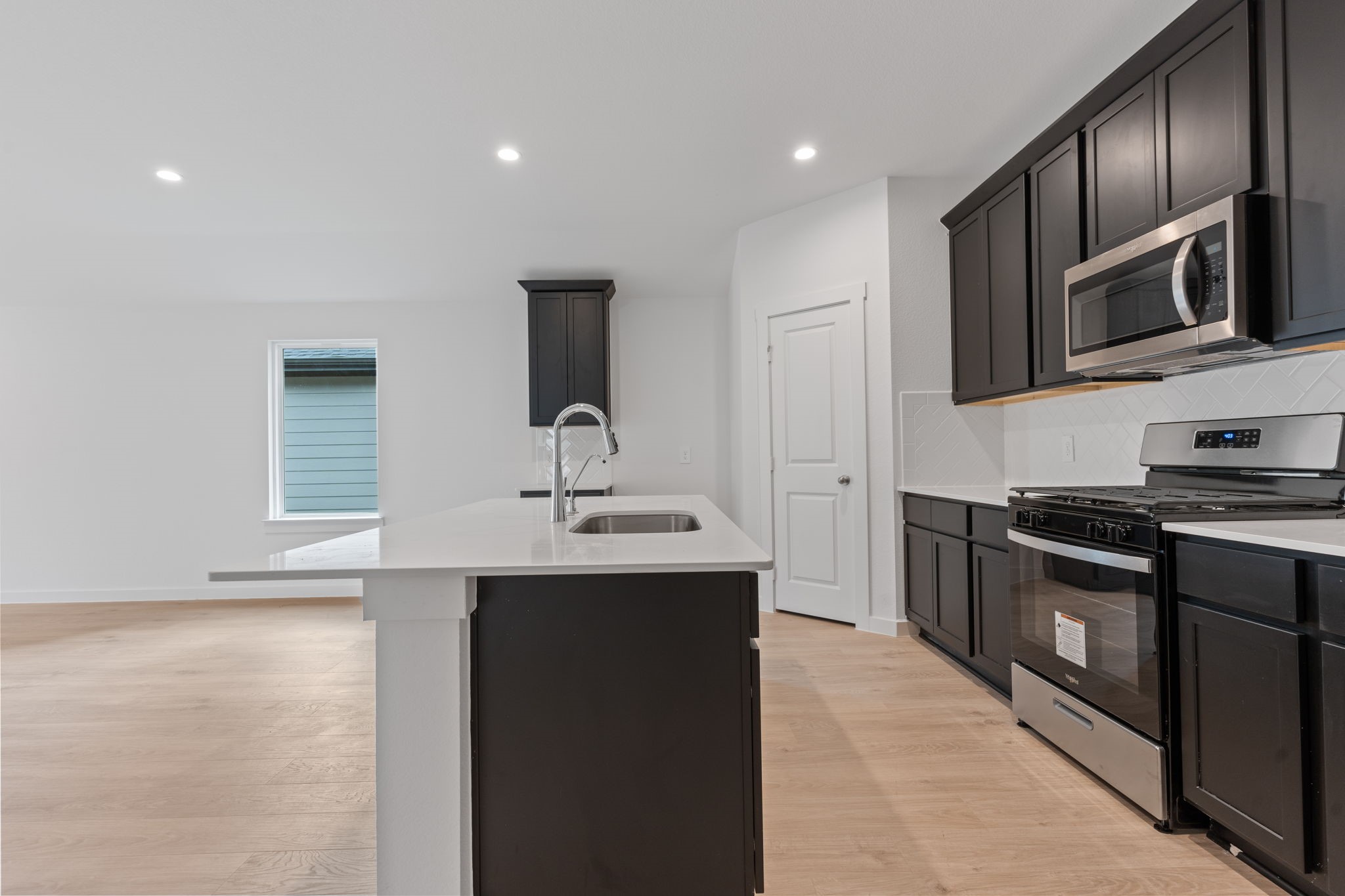 1603 Cinque Terre Way Richmond, TX 77406 - Photo 10 of 31 a kitchen with stainless steel appliances a sink stove and microwave