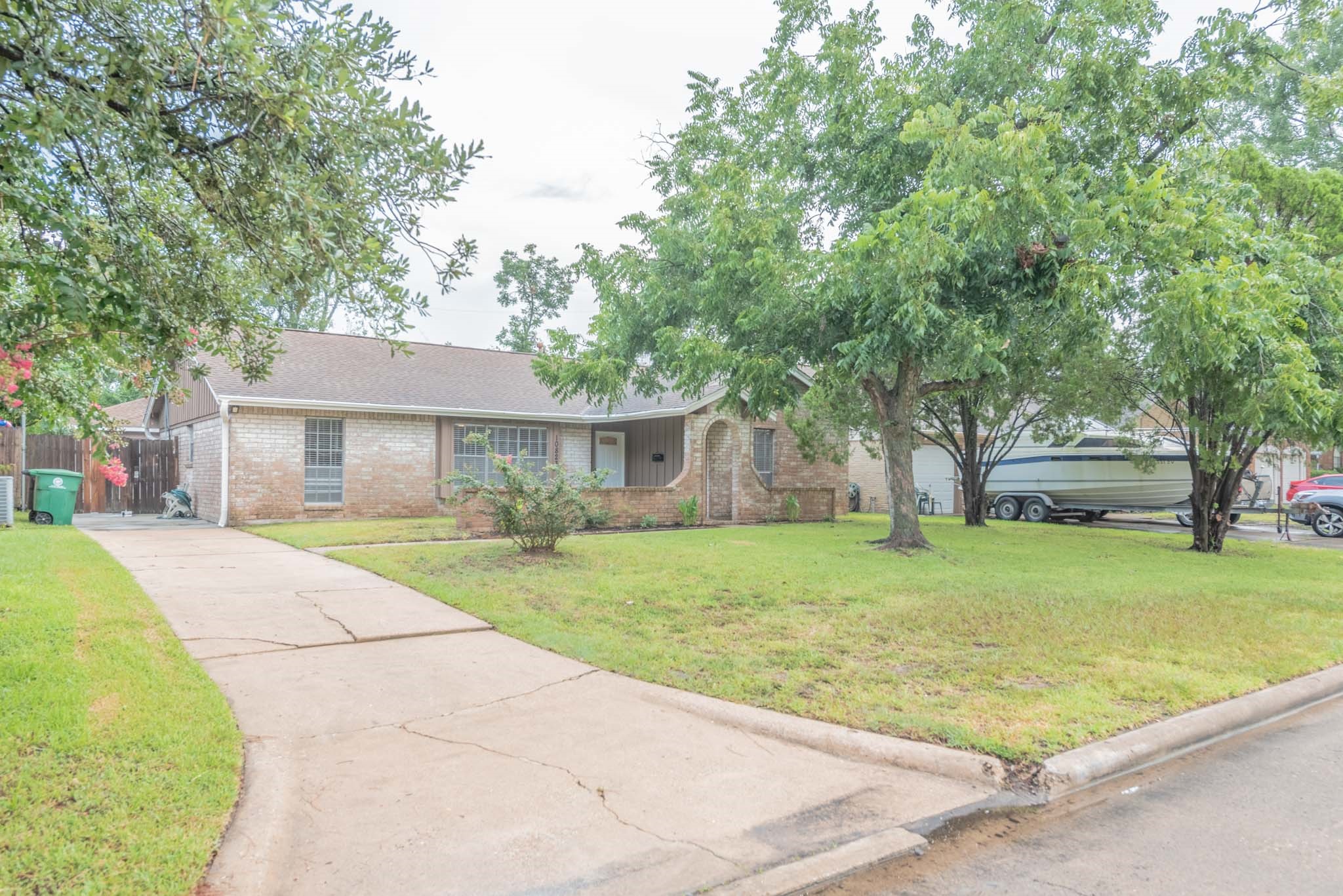 10823 Overlea Drive Houston, TX 77089 - Photo 3 of 36 a front view of a house with a garden and trees