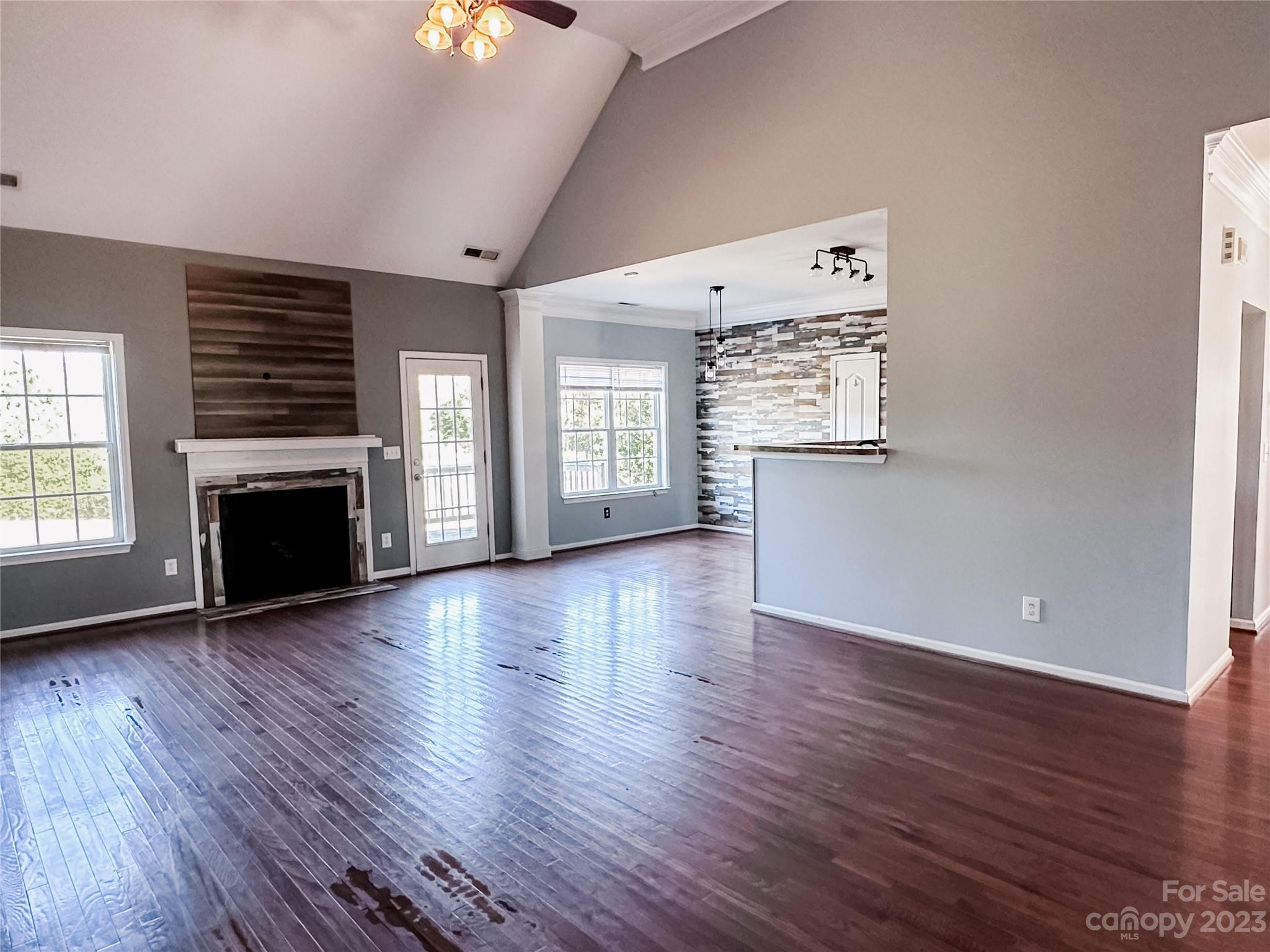 181 Weathers Creek Road Troutman, NC 28166 - Photo 11 of 25 an empty room with wooden floor a fireplace and windows