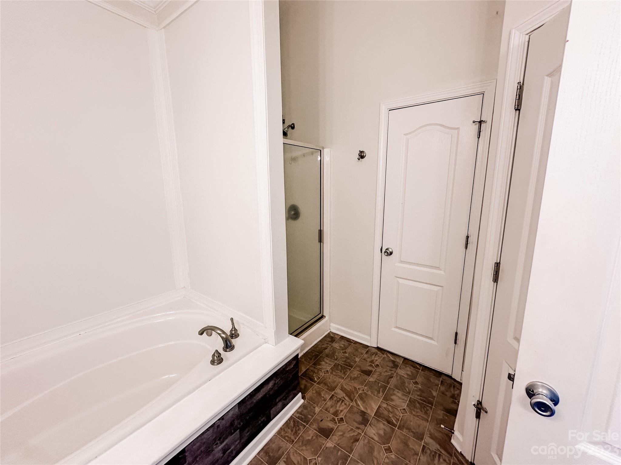 181 Weathers Creek Road Troutman, NC 28166 - Photo 15 of 25 a bathroom with a bathtub and shower