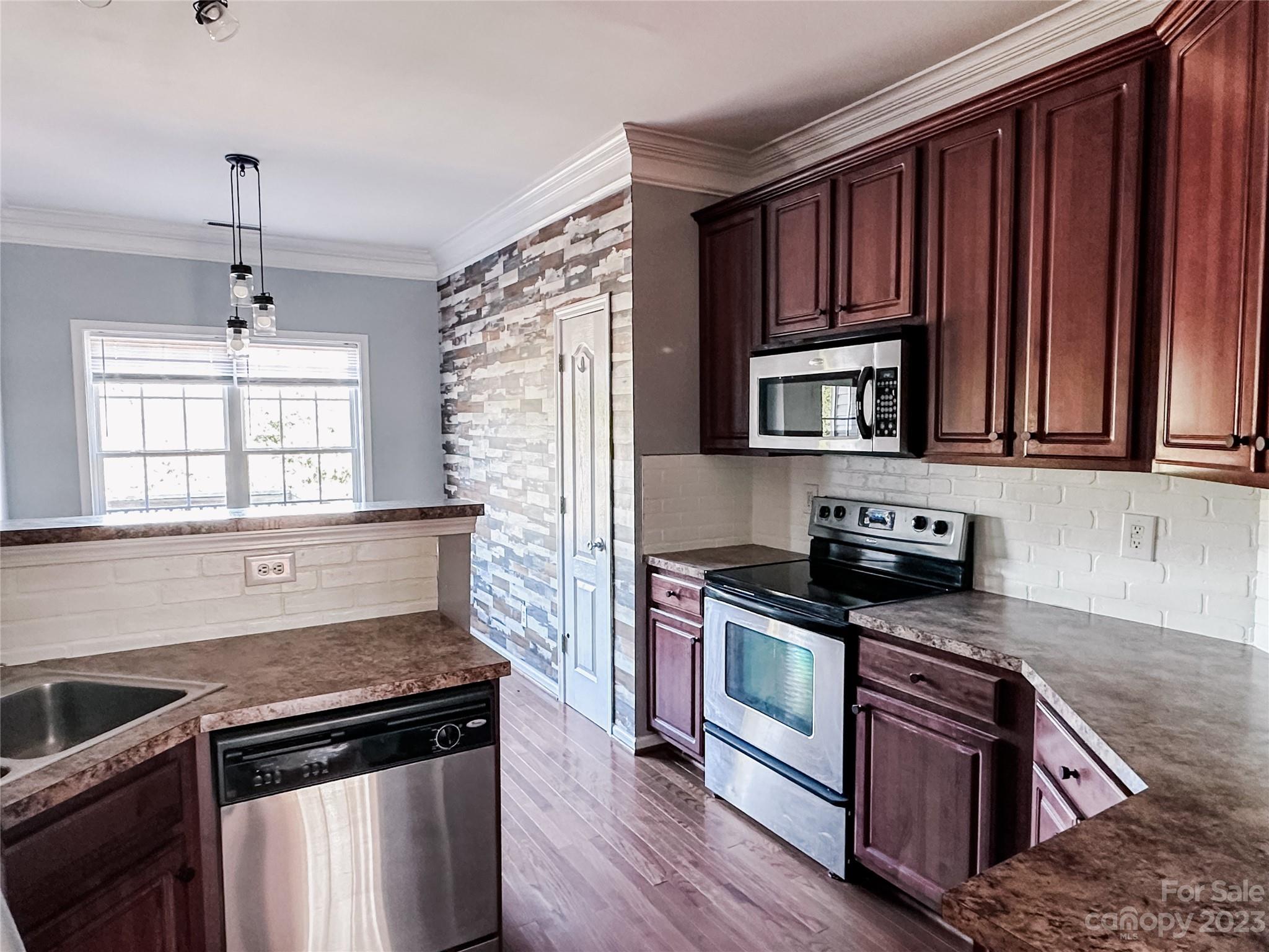 181 Weathers Creek Road Troutman, NC 28166 - Photo 5 of 25 a kitchen with granite countertop wooden cabinets stainless steel appliances and a window
