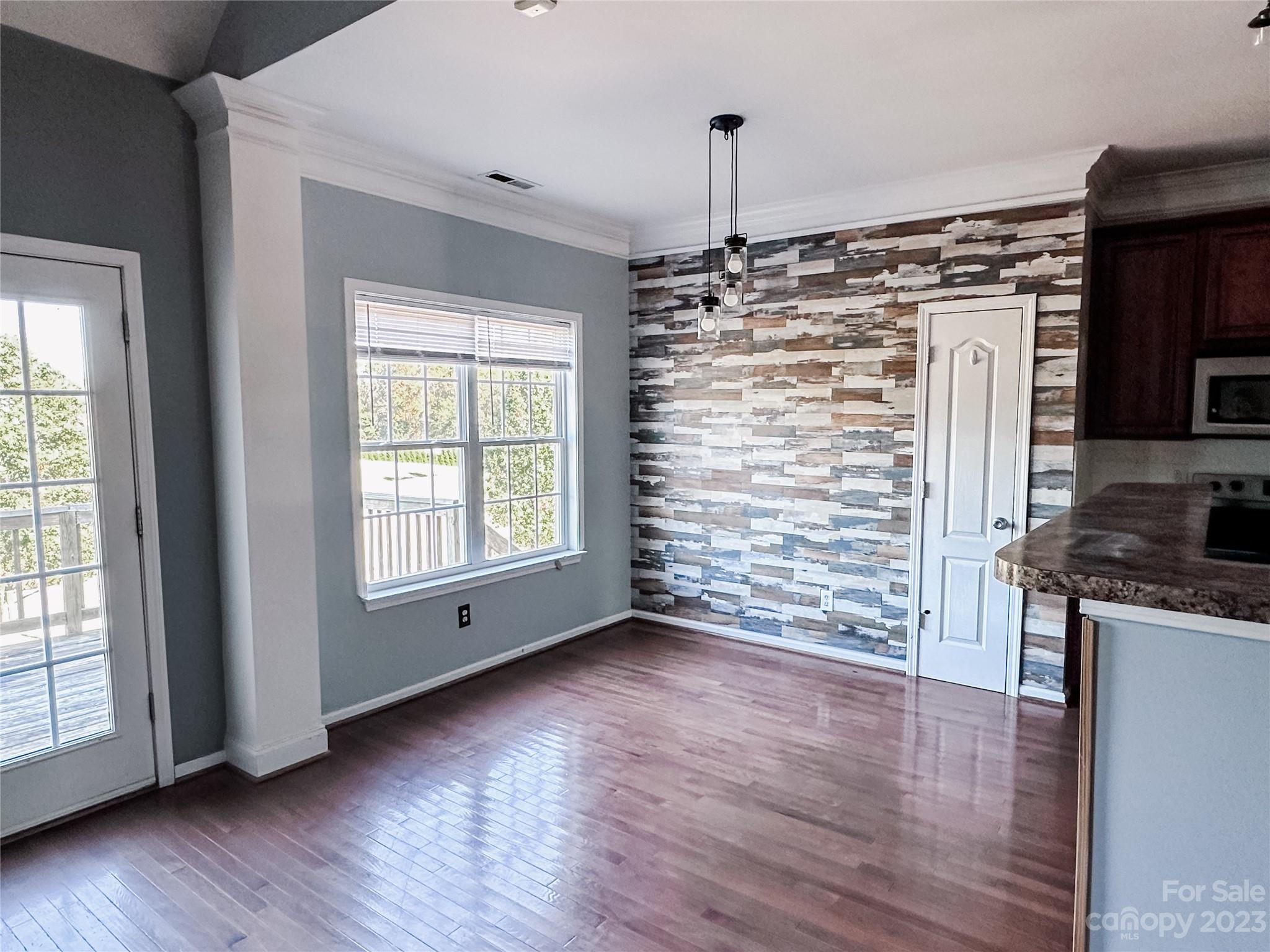 181 Weathers Creek Road Troutman, NC 28166 - Photo 7 of 25 a view of empty room with kitchen appliances and wooden floor