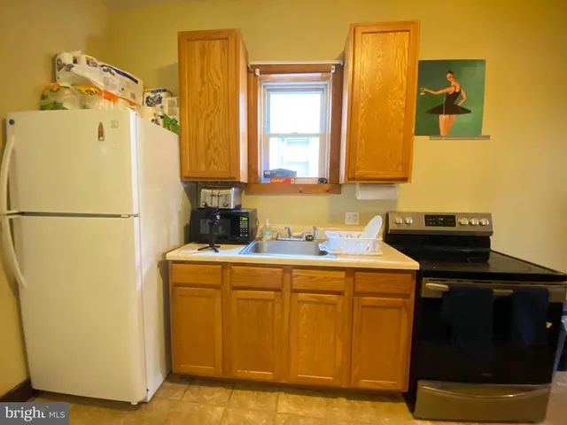 a utility room with a sink and a refrigerator