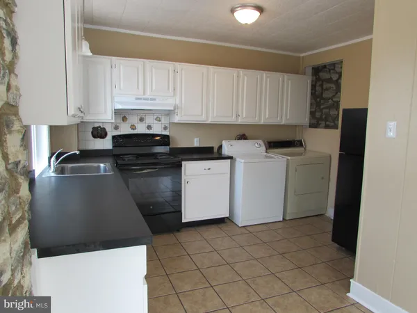 a kitchen with a sink a stove and cabinets