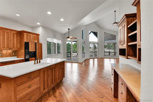 a large kitchen with stainless steel appliances a large counter top a stove and a sink