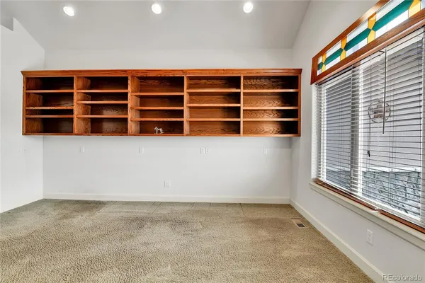 en empty room with windows and ceiling fan