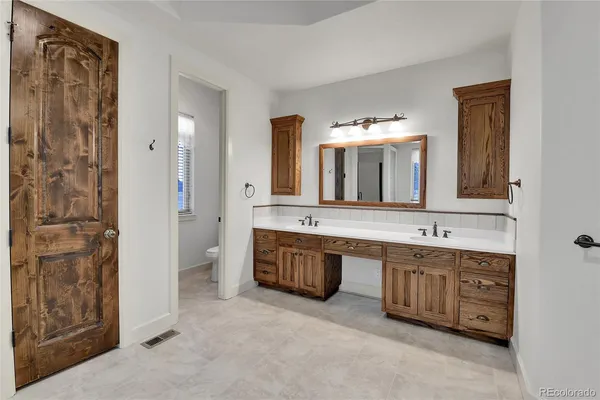 a spacious bathroom with a tub sink and mirror