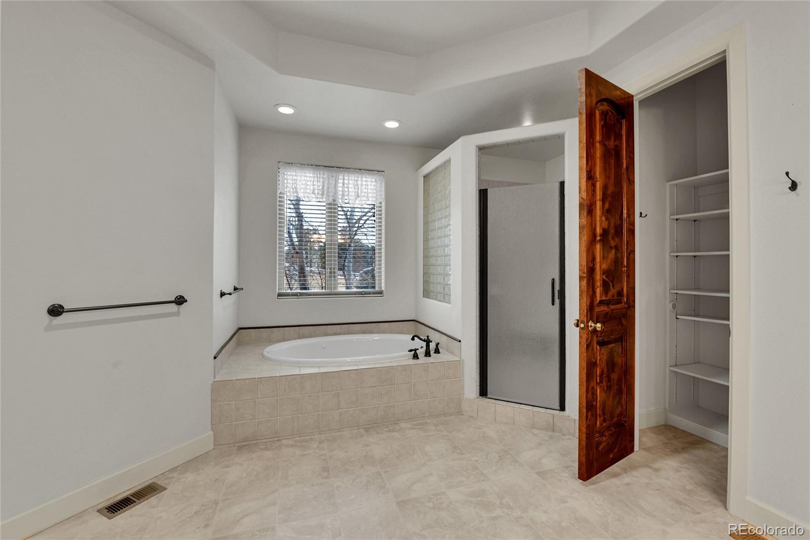 12984 Crowfoot Springs Road Franktown, CO 80116 - Photo 22 of 50 a spacious bathroom with a bathtub and a shower