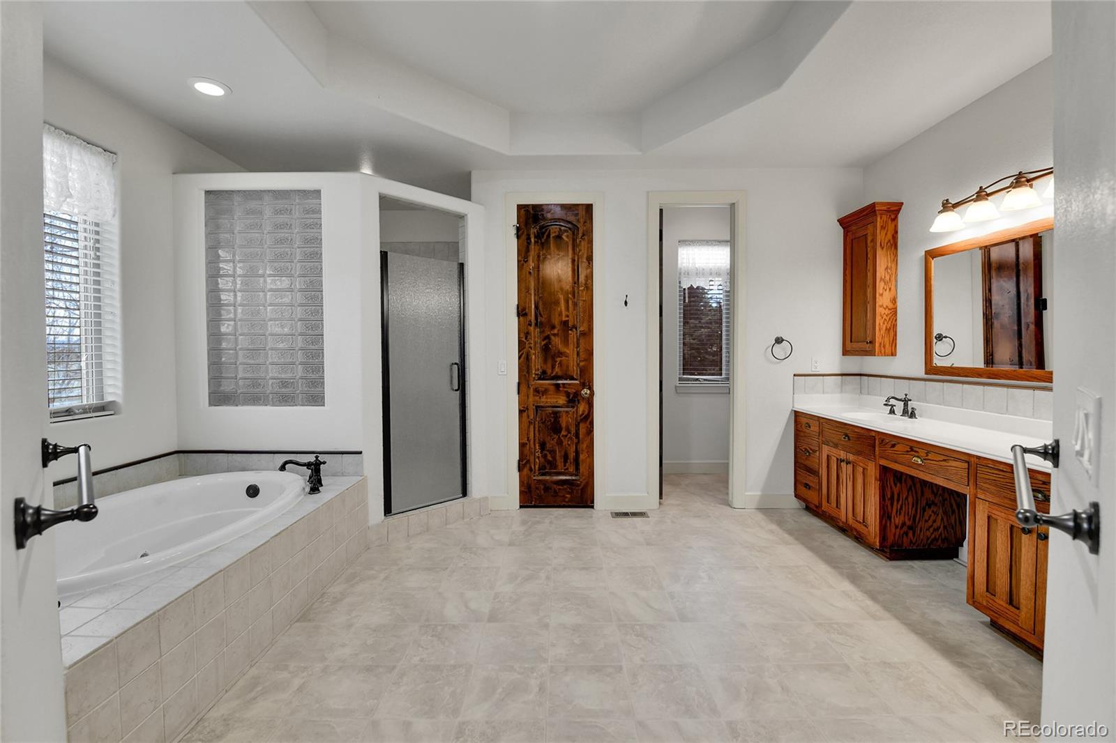 12984 Crowfoot Springs Road Franktown, CO 80116 - Photo 23 of 50 a spacious bathroom with a tub sink and mirror