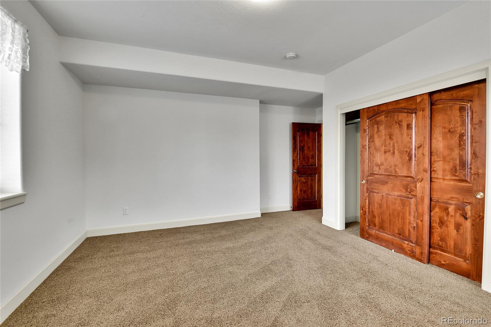 12984 Crowfoot Springs Road Franktown, CO 80116 - Photo 27 of 50 an empty room with sliding door
