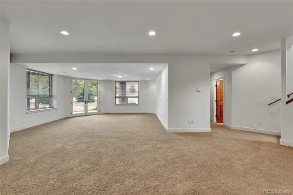 an empty room with windows and fireplace