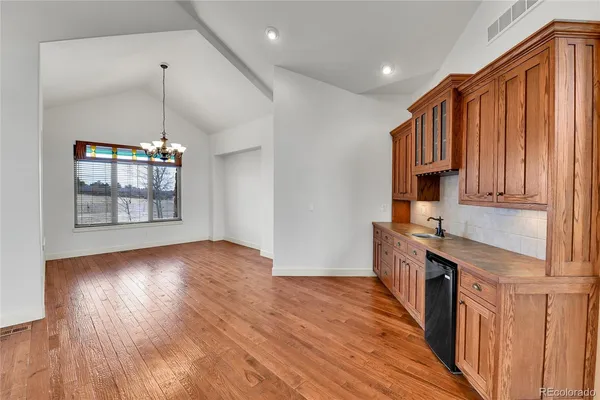 a view of a kitchen cabinets a kitchen island wooden floor and staircase