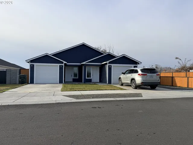 a front view of a house with a garden and parking space