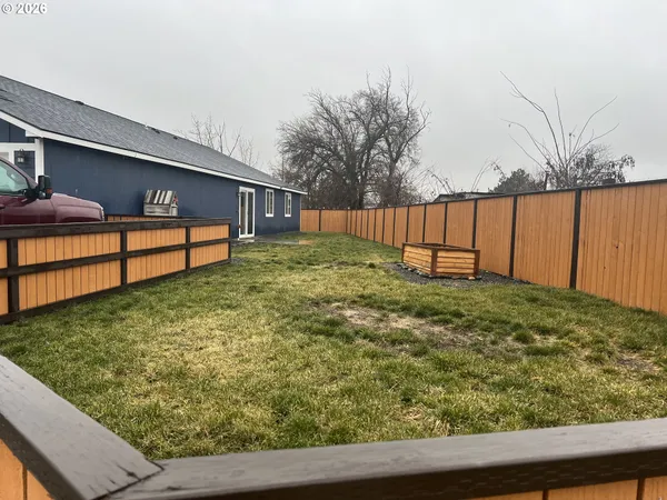 a view of backyard with wooden fence