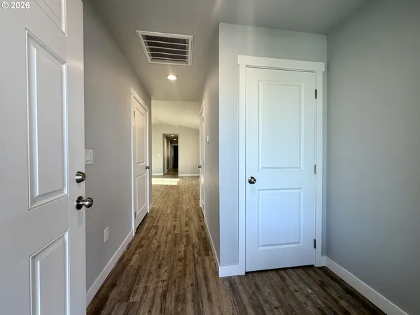 a view of a hallway with wooden floor and staircase