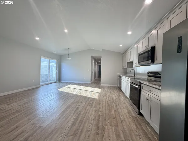 a kitchen with stainless steel appliances granite countertop a stove a sink and a refrigerator