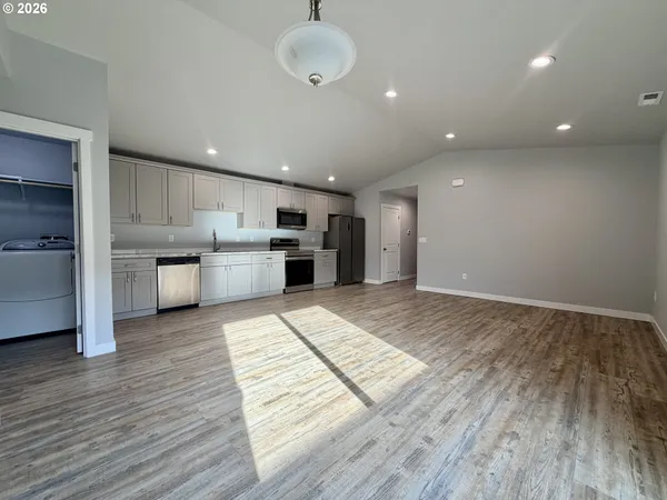 a open kitchen with stainless steel appliances granite countertop a refrigerator and a stove top oven