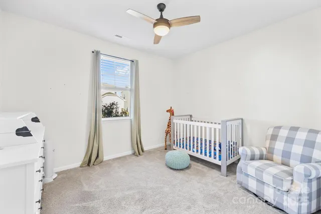 a view of an empty room with a window and ceiling fan