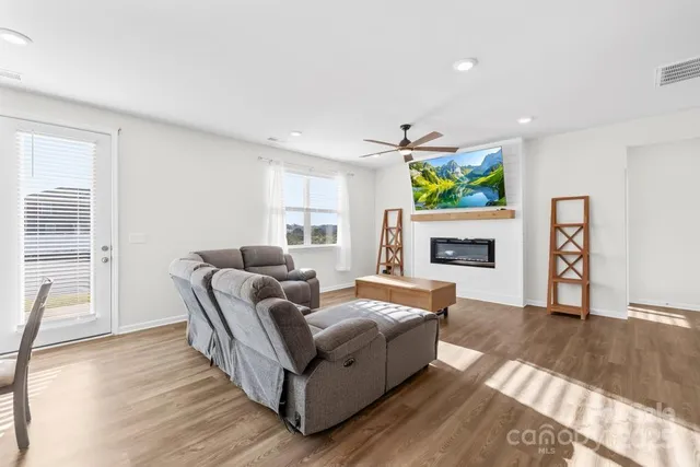 a living room with furniture a fireplace and a wooden floor