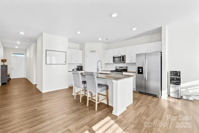 a kitchen with a refrigerator and a stove top oven