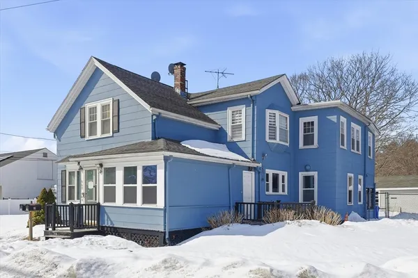 a front view of a house with a yard covered in snow