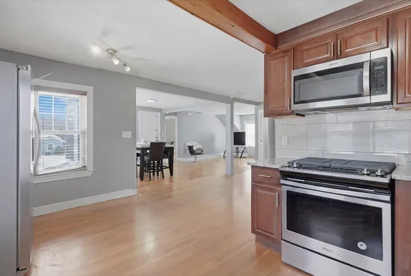 a kitchen with stainless steel appliances granite countertop white cabinets a sink and a dishwasher