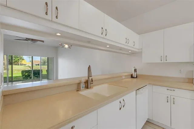 a kitchen with granite countertop white cabinets and white appliances