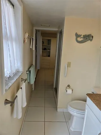 a bathroom with a granite countertop sink toilet and a mirror
