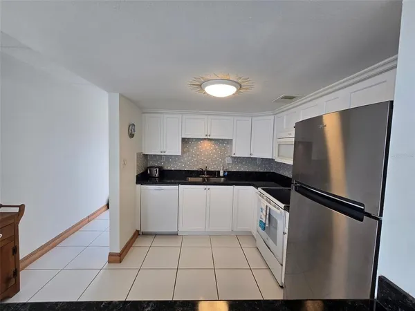 a kitchen with granite countertop white cabinets and stainless steel appliances