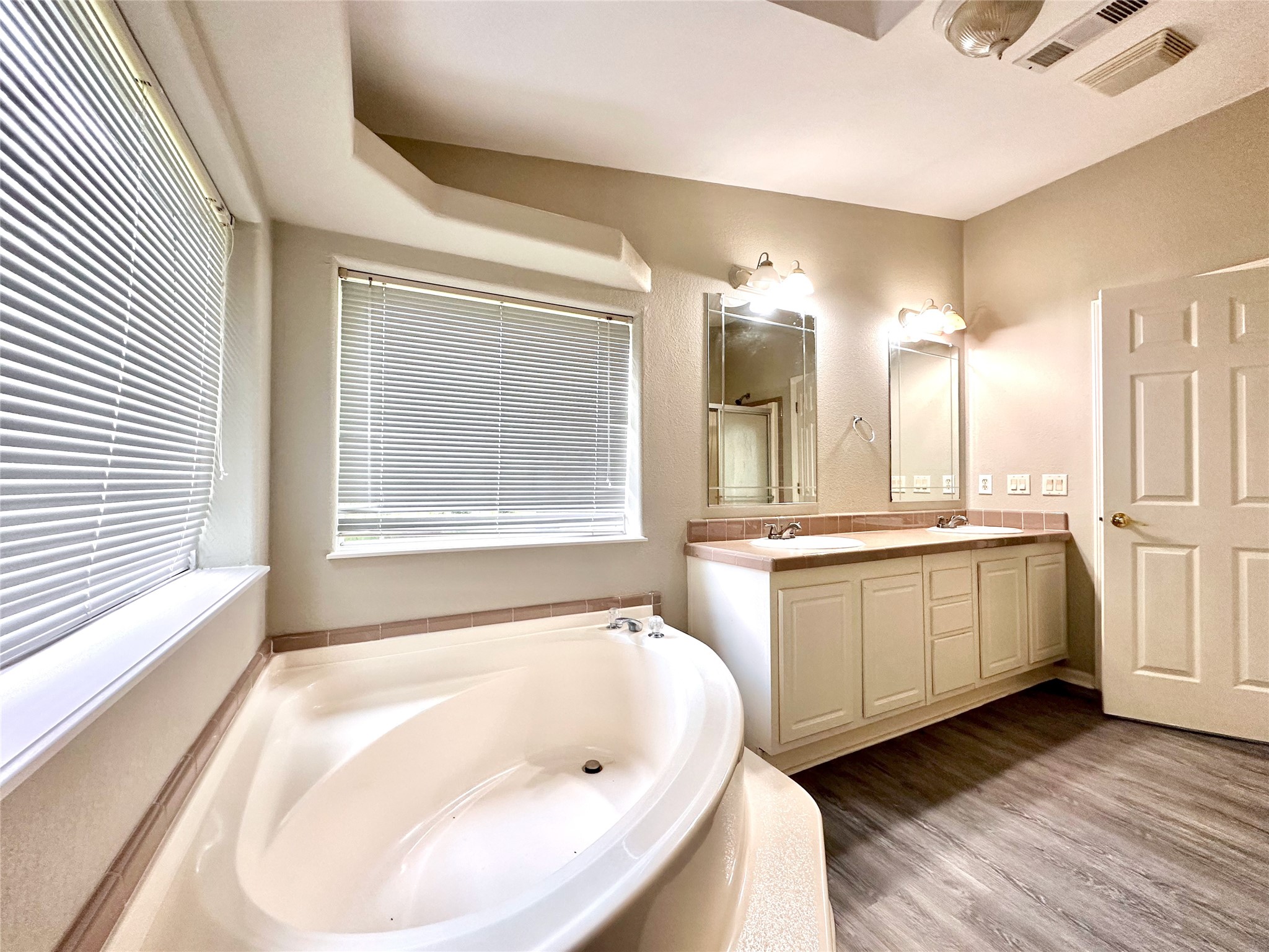 202 Main Street Fresno, TX 77545 - Photo 20 of 26 a bathroom with a bathtub a sink and a large window