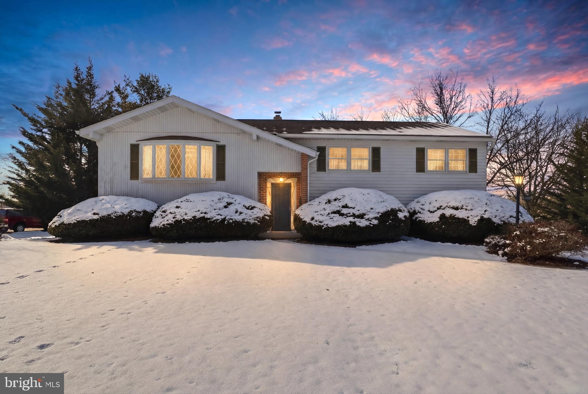 a front view of a house with a yard covered in snow