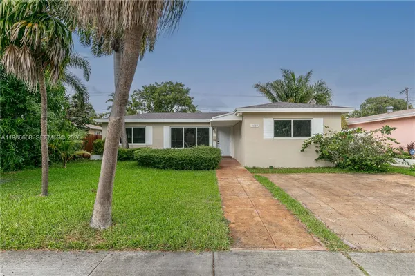 a front view of house with a yard and potted plants