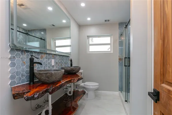 a bathroom with a toilet a sink and a mirror