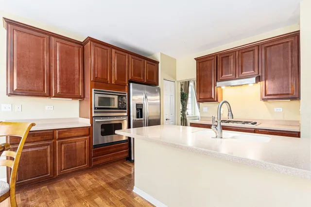 a kitchen with stainless steel appliances granite countertop a refrigerator sink and cabinets