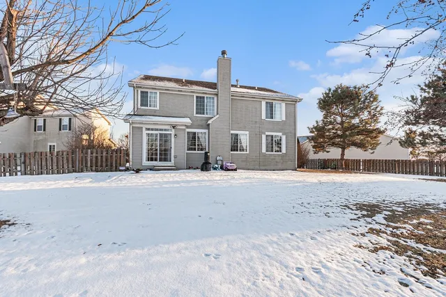 a front view of a house with a road and trees