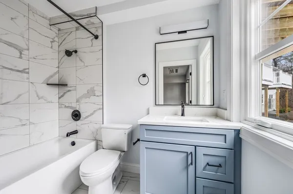 a bathroom with a sink toilet vanity and shower