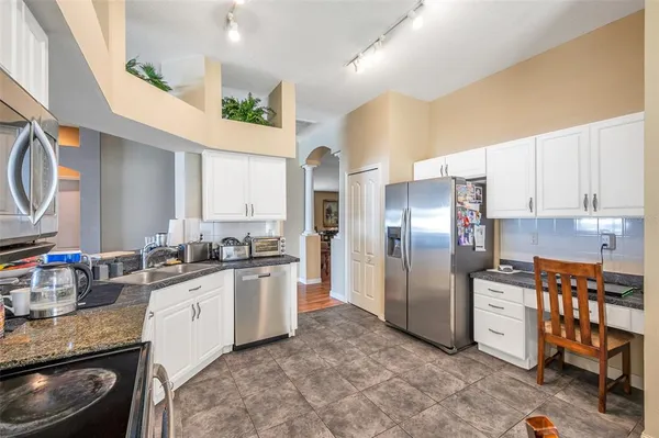 a modern kitchen with stainless steel appliances granite countertop a refrigerator and a sink