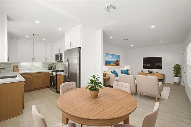 a kitchen with sink a refrigerator and dining table