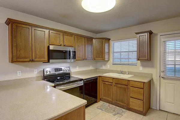 a kitchen with stainless steel appliances a stove sink microwave and cabinets
