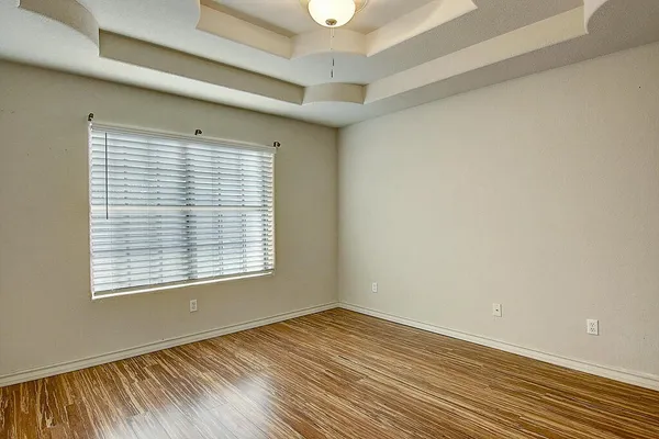 a view of a bedroom with wooden floor and a window